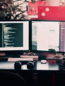 two black computer monitors on black table